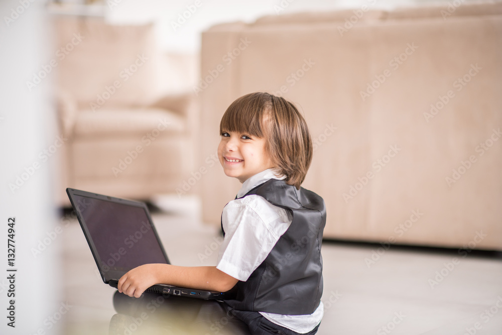 Cute kid with laptop on ground at home Cute kid with laptop on ground at home