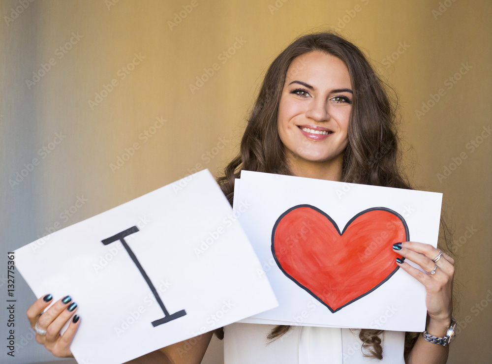 Young pretty beautiful woman holding a peace of paper with big r Young pretty beautiful woman holding a peace of paper with big r