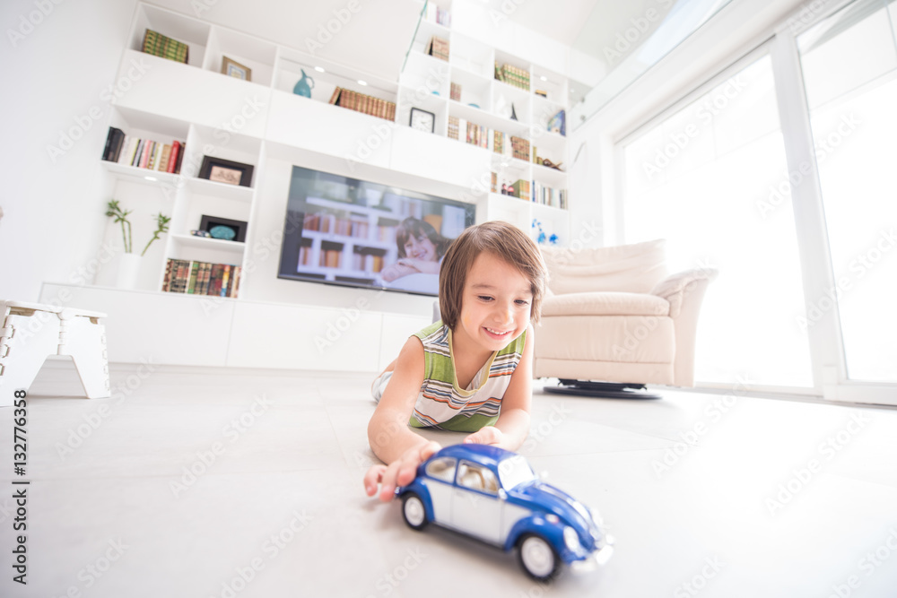 Happy kid playing with old car toy at home