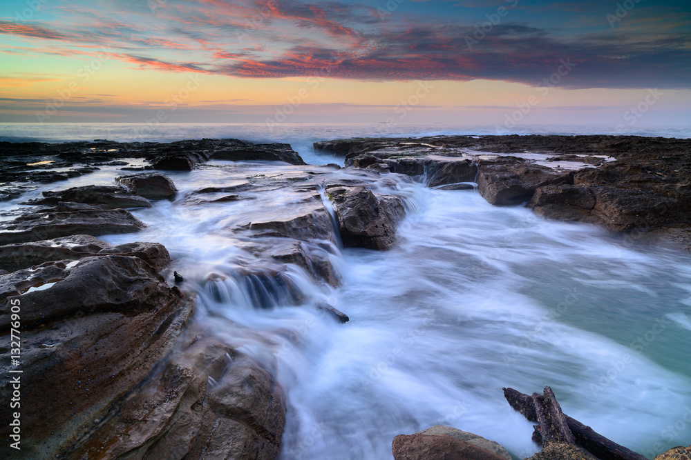 Wave flows over weathered rocks and boulders at North Narrabeen Wave flows over weathered rocks and boulders at North Narrabeen