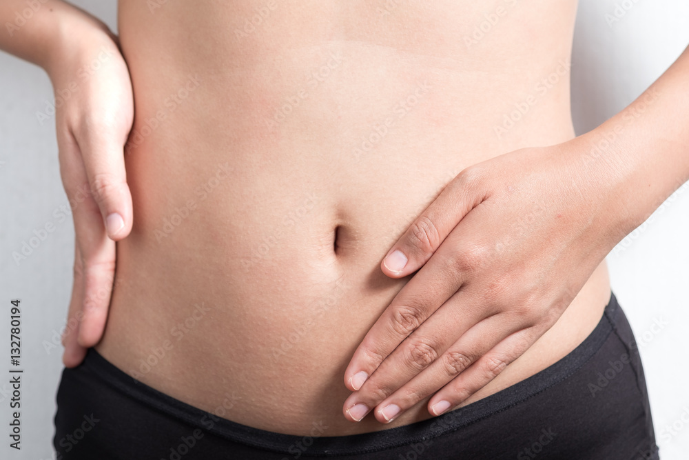 Pregnancy or diet concept, female hands protecting the stomach on white background. Pregnancy or diet concept, female hands protecting the stomach on white background.