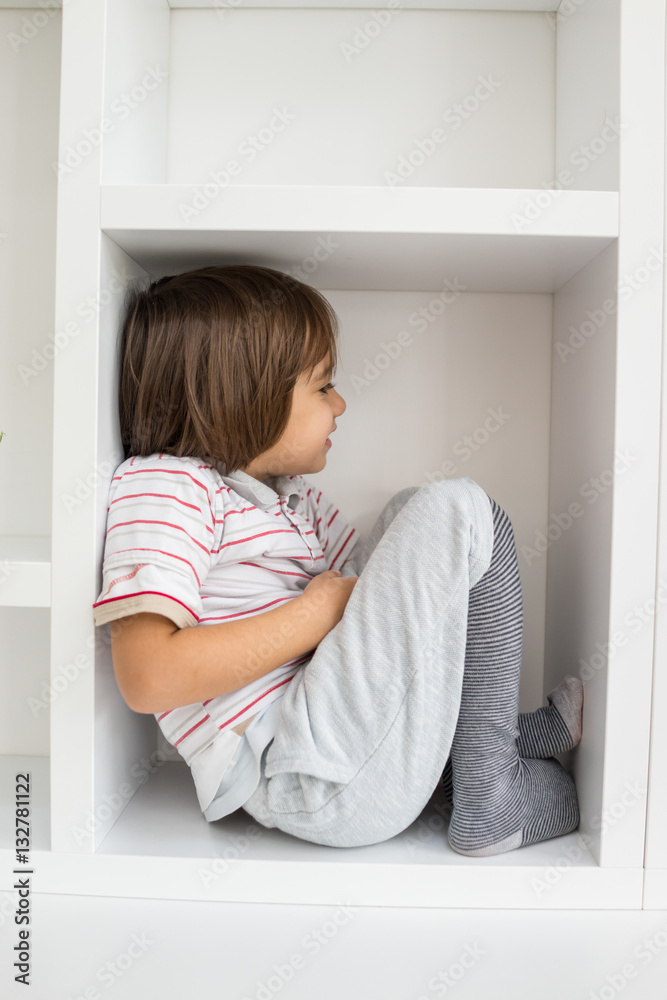 Child in shelf inside living room Child in shelf inside living room