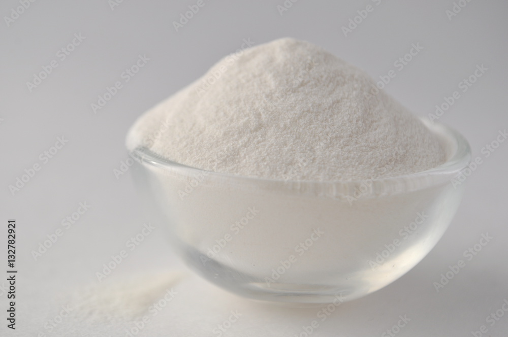 Xanthan gum - a white powder of plant origin for gluten free baking and cooking, closeup on white background
