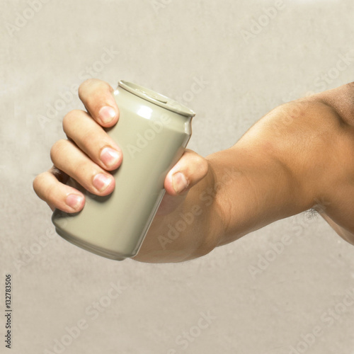 Close-up of an empty can in a strong hand.
