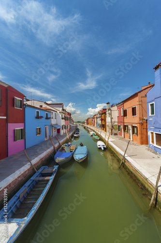 Burano island canal, colorful houses and boats, Venice, Italy.