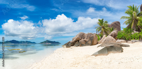 Tropical beach at Seychelles on La Digue island and Praslin island on the horizon. Panoramic image.