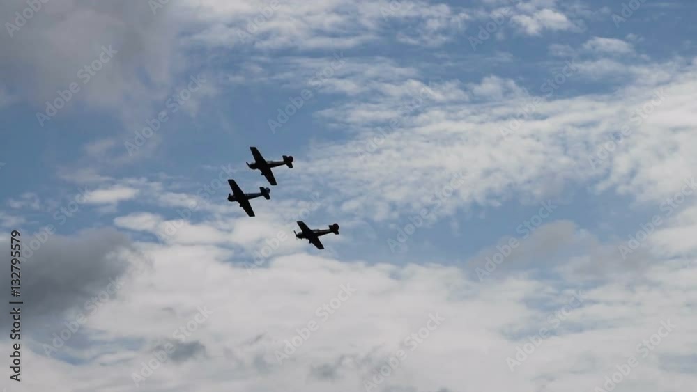 Three retro planes performing in cloudy sky Three retro planes performing in cloudy sky