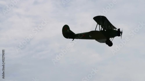 Retro plane flying in blue sky. Black silhouette