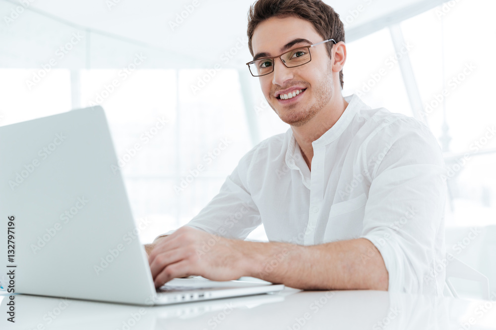 Happy young man using laptop computer. Happy young man using laptop computer.