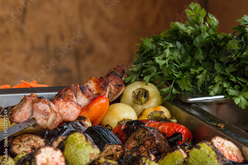Pan with grilled vegetables, pepper, eggplants, zucchini, grilled meat,..parsley on background. Food festival on open air