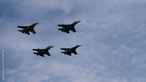 Four fighter planes flying overhead close to each other