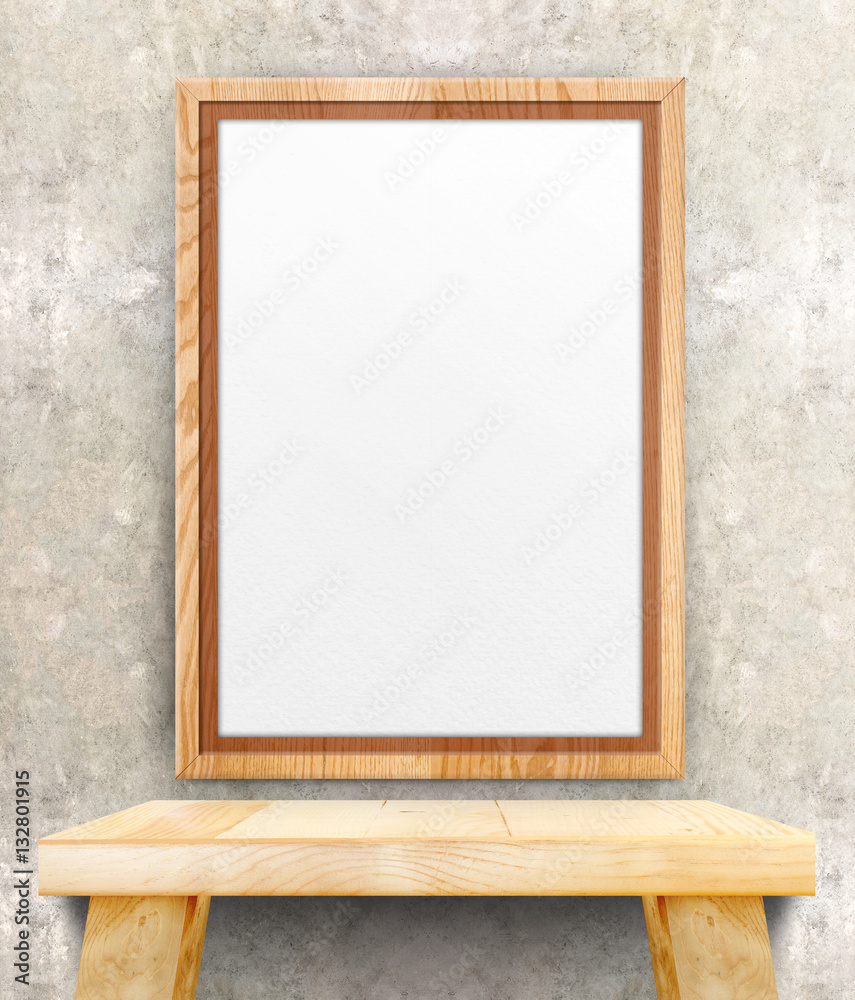 Fototapeta premium Blank wooden photo frame hanging at clean concrete wall on wood