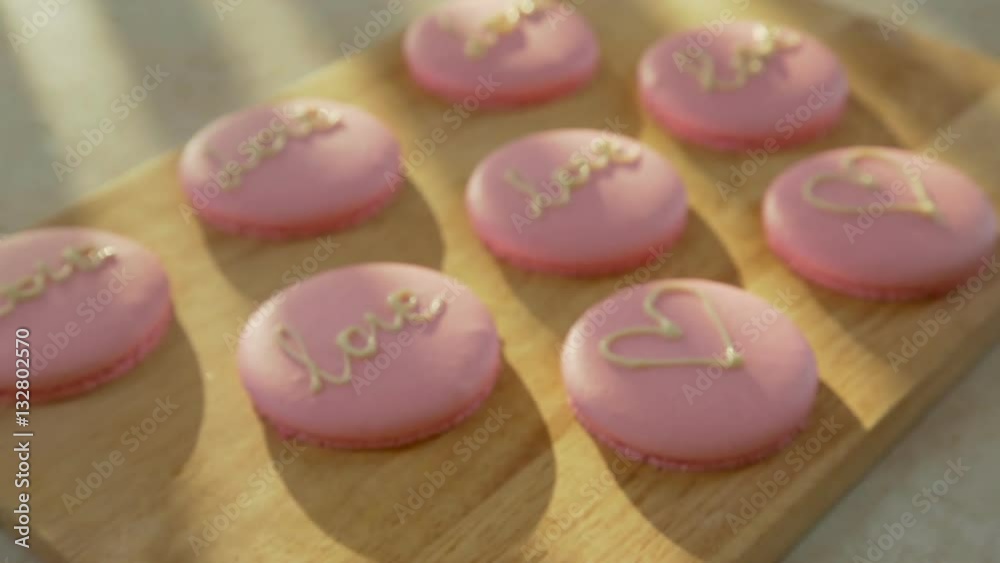 Pink macaroon - biscuits and modern dessert. Macaroon decorated with hearts and the words love for 14 February. Treats for the day of lovers. Bake on parchment paper Pink macaroon - biscuits and modern dessert. Macaroon decorated with hearts and the words love for 14 February. Treats for the day of lovers. Bake on parchment paper
