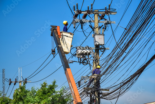 Electrician perform maintenance on the transmission towers with use of claws- manholes and belt