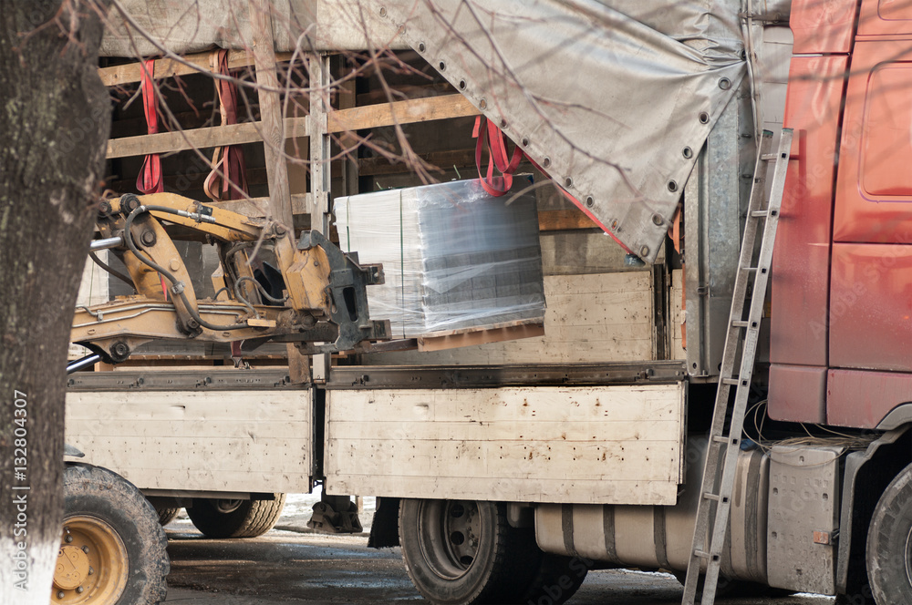 Fototapeta premium forklift unloads the pallet with the load of the car