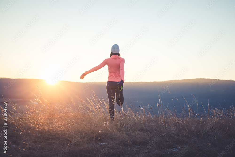 Runner girl stretching on top of the hill Runner girl stretching on top of the hill