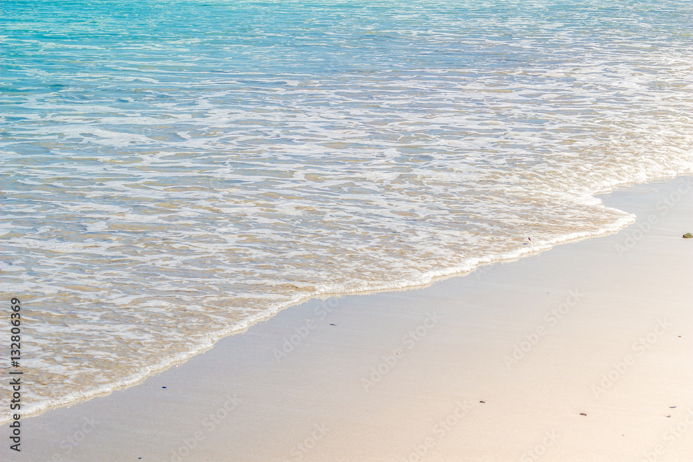 Soft wave of blue ocean on wet sandy beach. Background Soft wave of blue ocean on wet sandy beach. Background