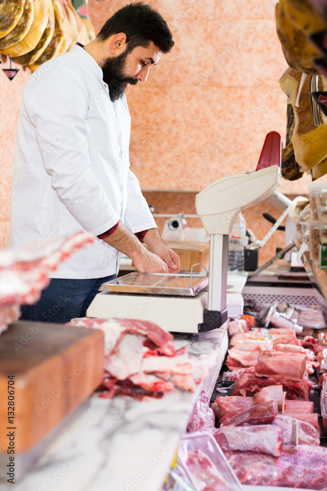 assistant arranging meat