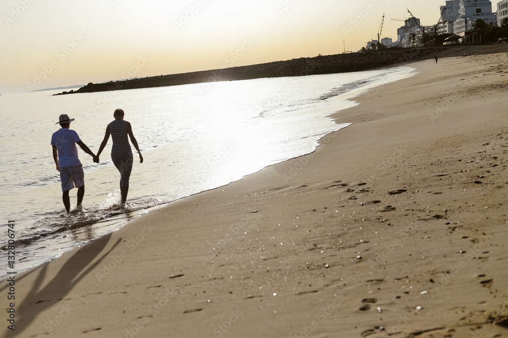 Naklejka premium Black and white image of couple in love on sunny beach outdoor background, back view. Valentines day travel vacation holiday relaxed lifestyle