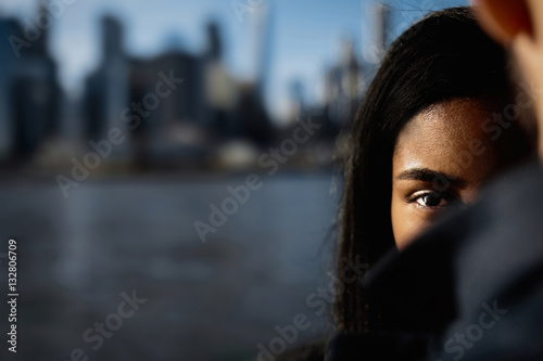 Look over man's shoulder at woman standing before NY cityscape photo