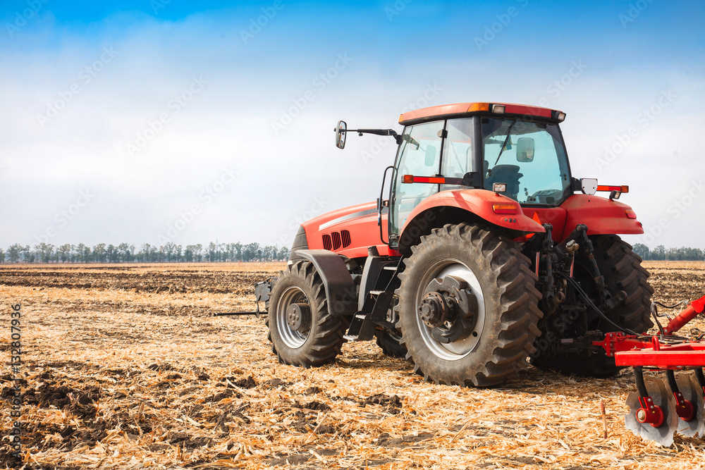 Red tractor in the field on a bright sunny day. Red tractor in the field on a bright sunny day.
