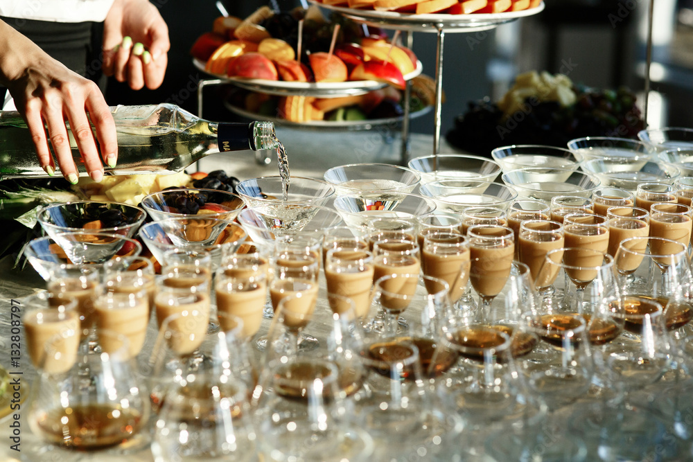 Glasses with whisky and cocktails stand on bar with fruits