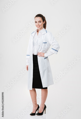 Full length of smiling pretty young woman doctor