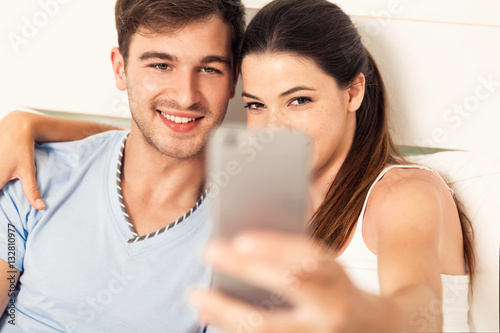 Couple on bed making selfies