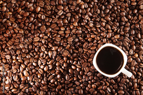 Coffee background. Coffee beans and cup of coffee over table.