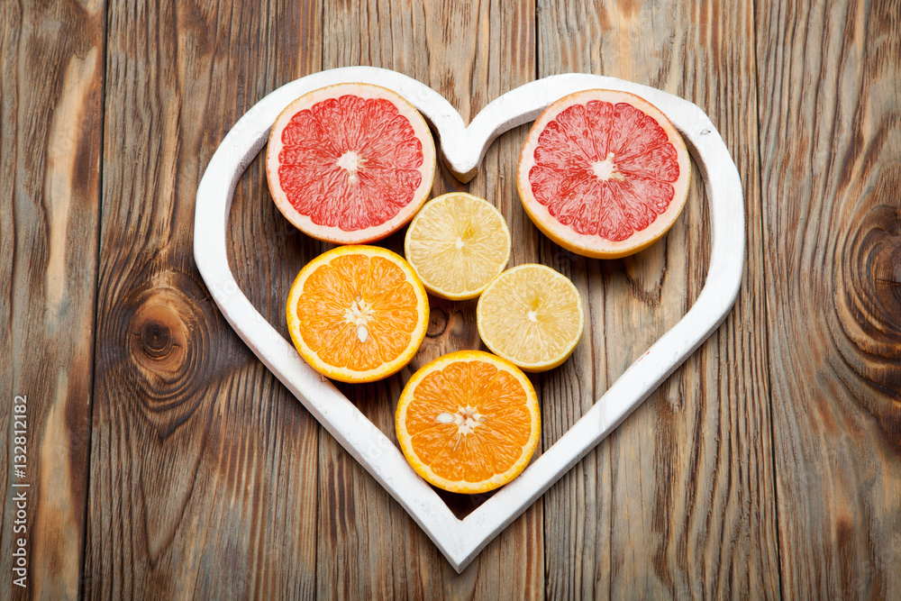 Citrus fruit in a heart on wooden background Citrus fruit in a heart on wooden background