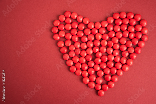 Red candy Heart shape over black background