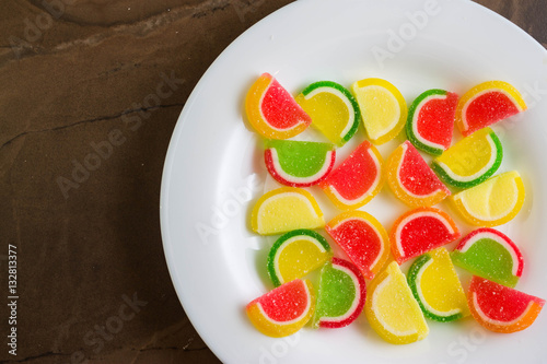 Multicolored fruit jellies on a white plate. Delicious and beautiful dessert.