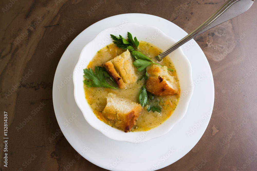 Pea soup with croutons in a white bowl on a marble table Pea soup with croutons in a white bowl on a marble table