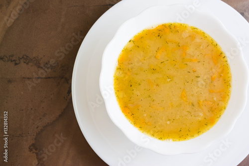 Pea soup in a white bowl on a marble table