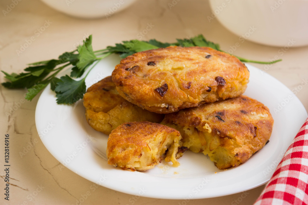 Potato patties with fried onions on a white plate Potato patties with fried onions on a white plate