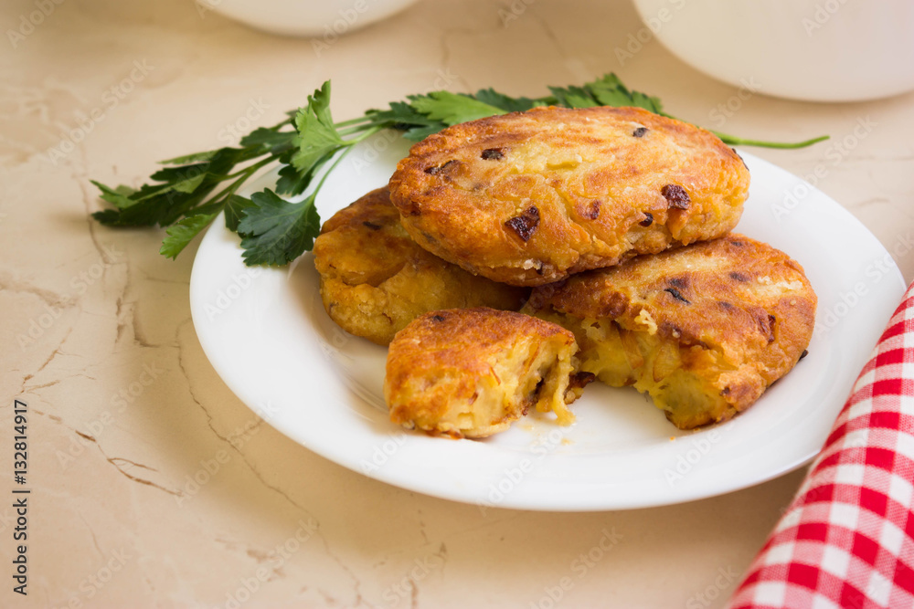 Potato patties with fried onions on a white plate Potato patties with fried onions on a white plate