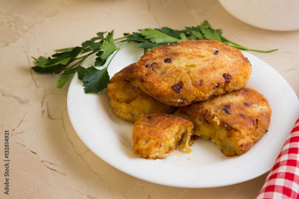 Potato patties with fried onions on a white plate Potato patties with fried onions on a white plate