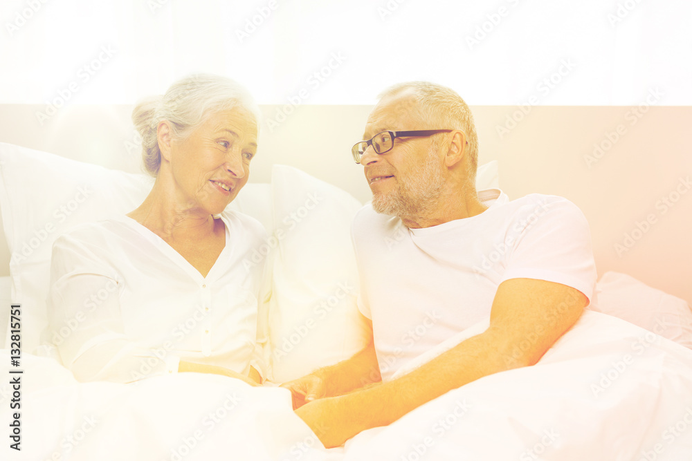 happy senior coupler lying in bad at home happy senior coupler lying in bad at home