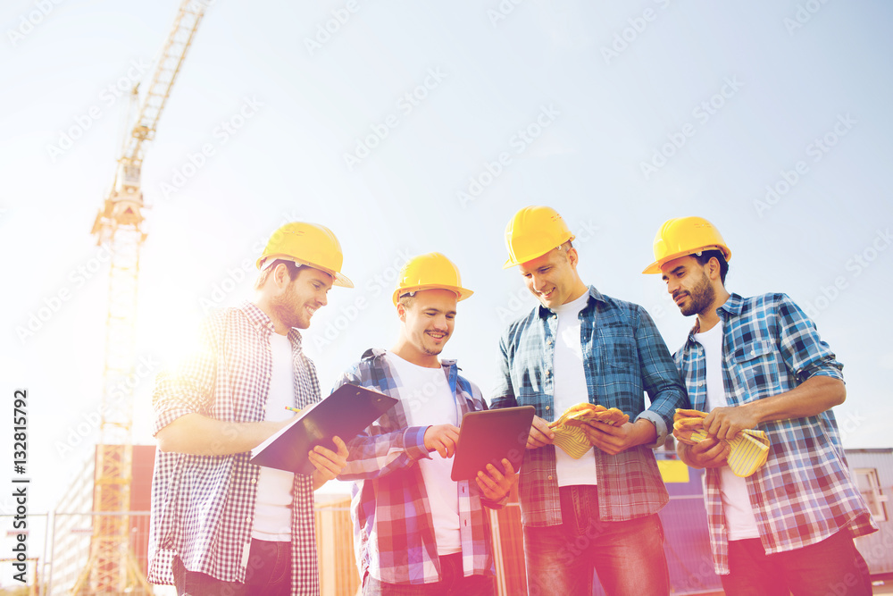 group of smiling builders with tablet pc outdoors group of smiling builders with tablet pc outdoors