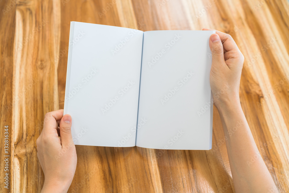 Hands open book on wood table . Hands open book on wood table .