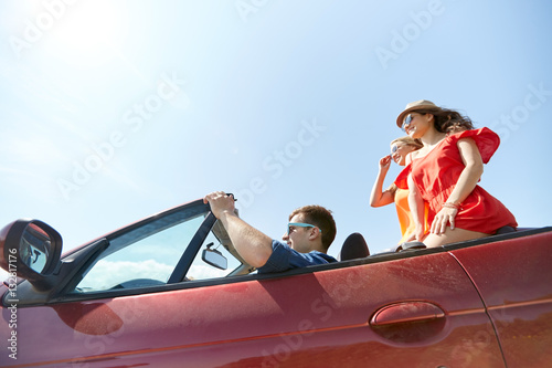 happy friends driving in cabriolet car outdoors © Syda Productions