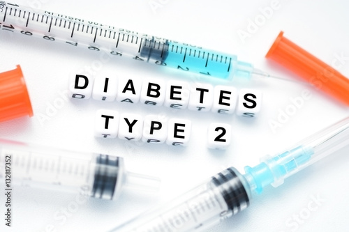 Type 2 diabetes text spelled with plastic letter beads placed next to an insulin syringe photo
