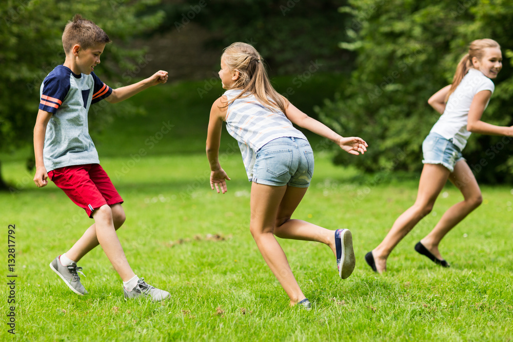 group of happy kids or friends playing outdoors group of happy kids or friends playing outdoors