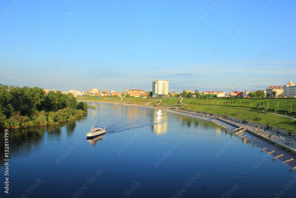 The ship floats on the river Tour along the waterfront, in the centre of Tyumen city in clear weather