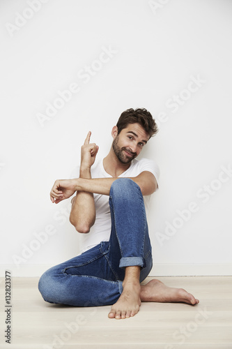 Guy sitting on floor and pointing upwards