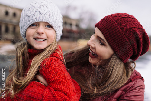beautiful young woman hugging little girl. mother and daughter enjoy life outdoor