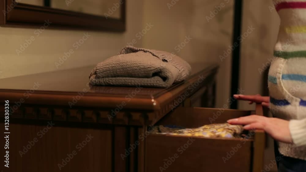 Girl gets baby sweater from the wooden dresser. Girl gets baby sweater from the wooden dresser.