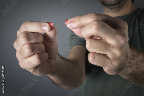 Close up image of a hand with a red pills.