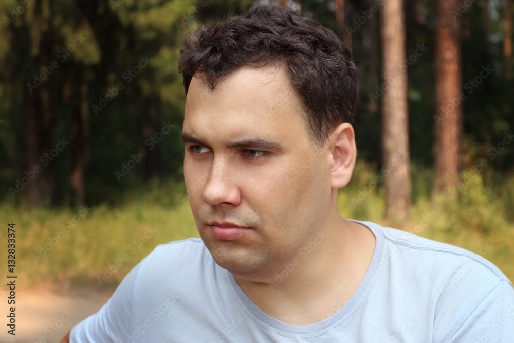 Sad man looks away and thinks at sunny summer forest, shallow do Sad man looks away and thinks at sunny summer forest, shallow do