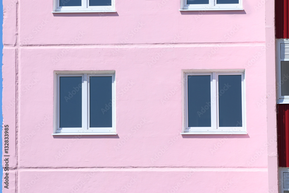 Part of pink residential building with windows with double glazi